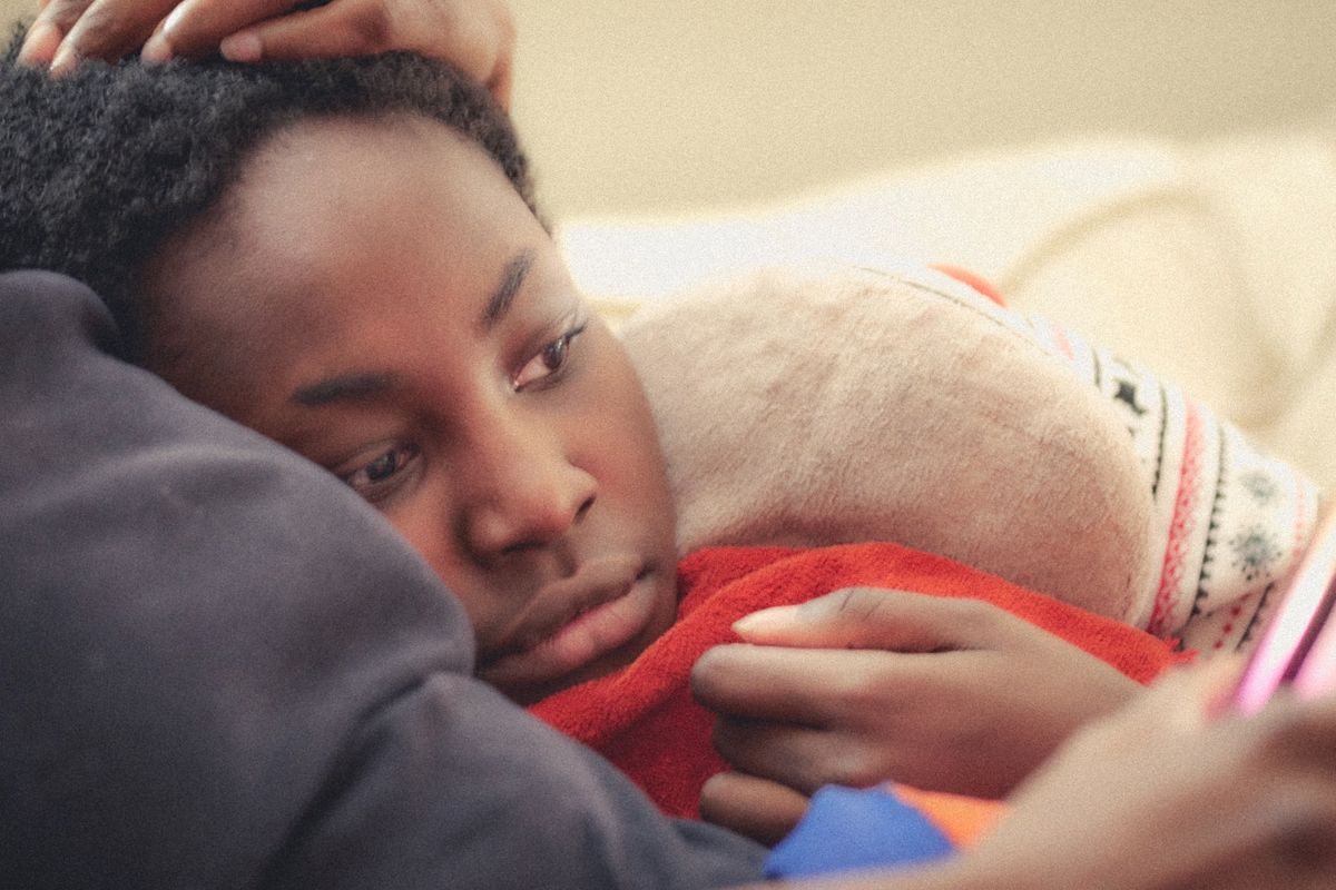 だきかけられた黒人の男の子