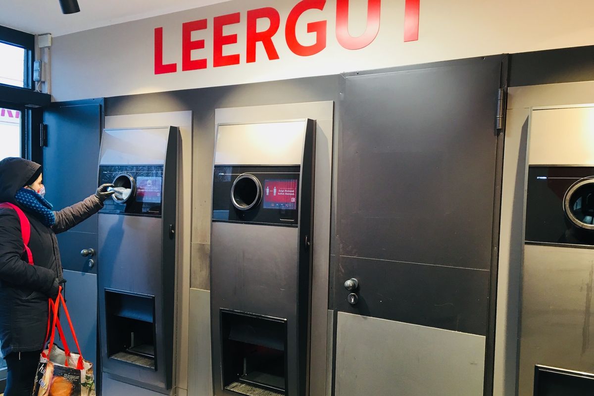 ドイツの空き瓶回収ボックスと瓶を入れる人