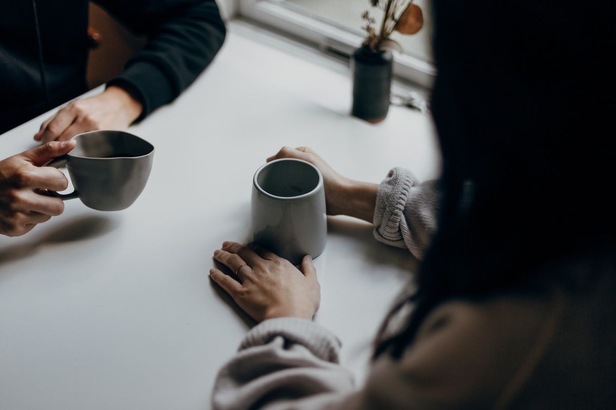 コーヒーカップ片手に語り合う二人の女性
