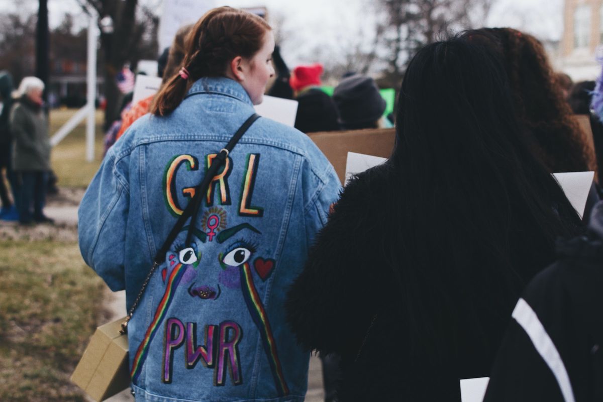 「GRL PWR」とプリントされたGジャンを着た女性の後ろ姿
