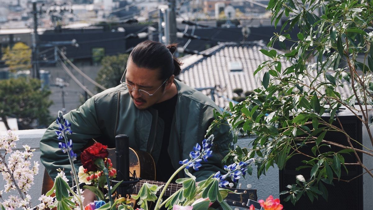 ギターを弾く新羅慎二氏