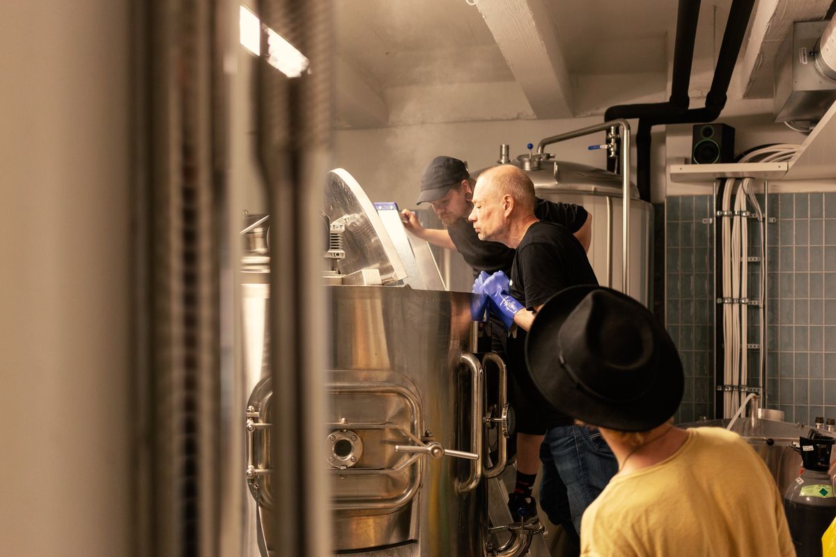 釜の中をのぞく男性スタッフ２名とそれを見守るスタッフ１名