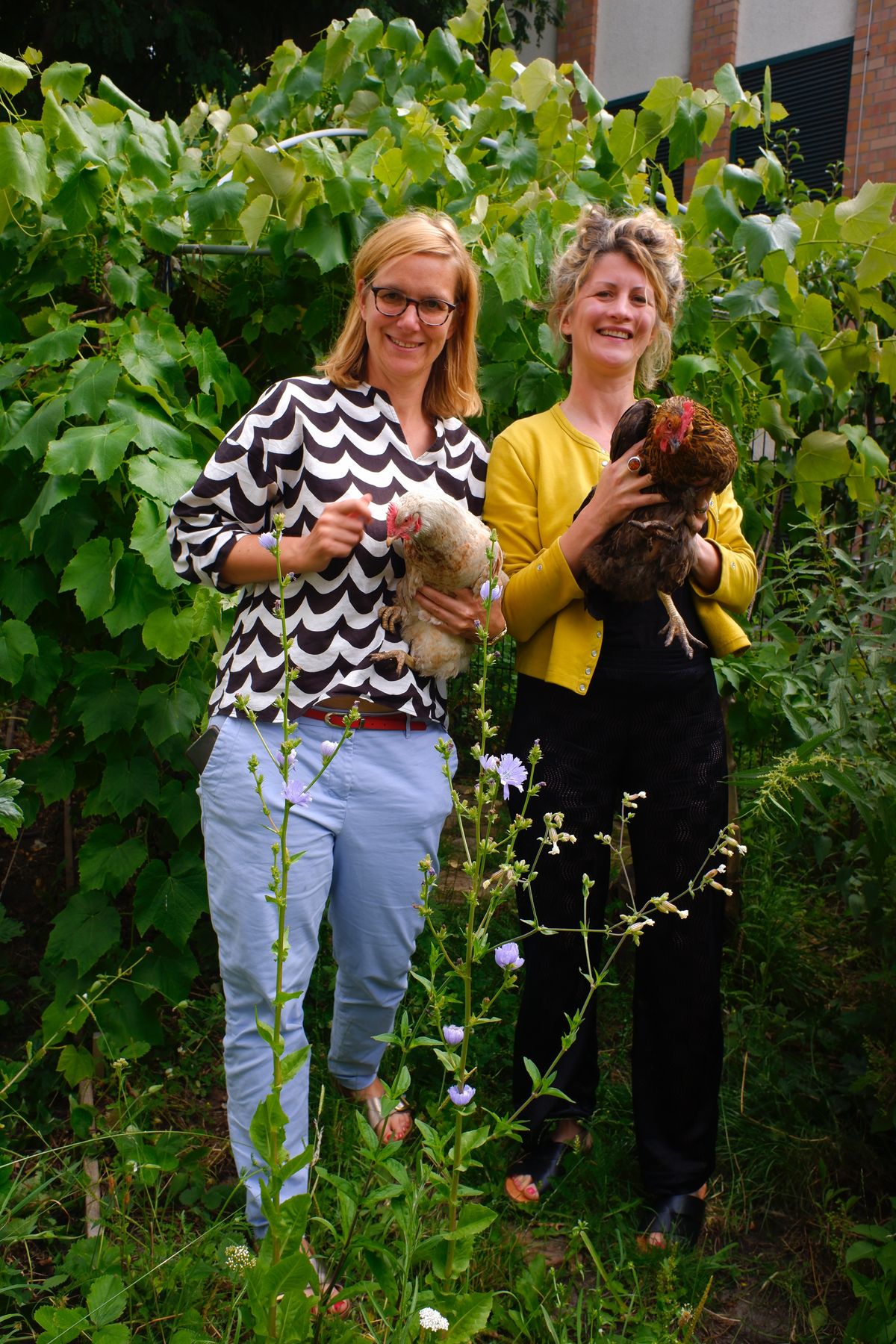 エルケ・ファラットさん（左）とアナ・ザテラロ・シェンクさん（右）とガーデンの鶏