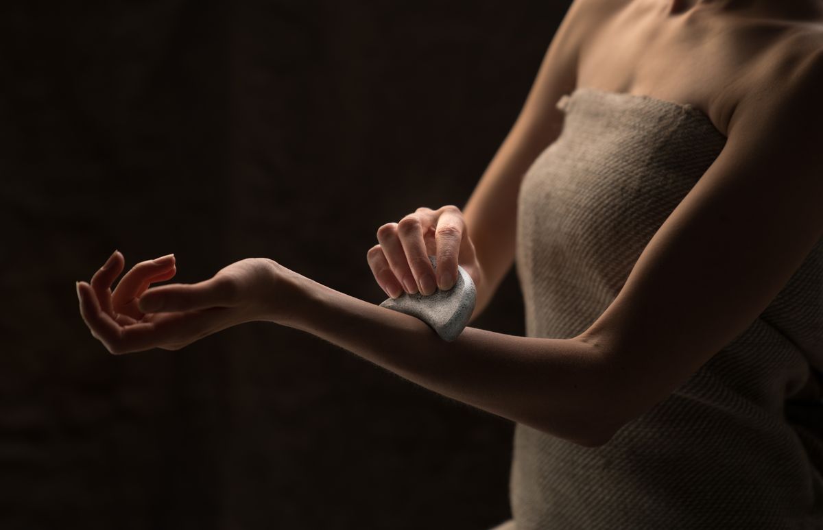 カッサで腕のマッサージをする女性