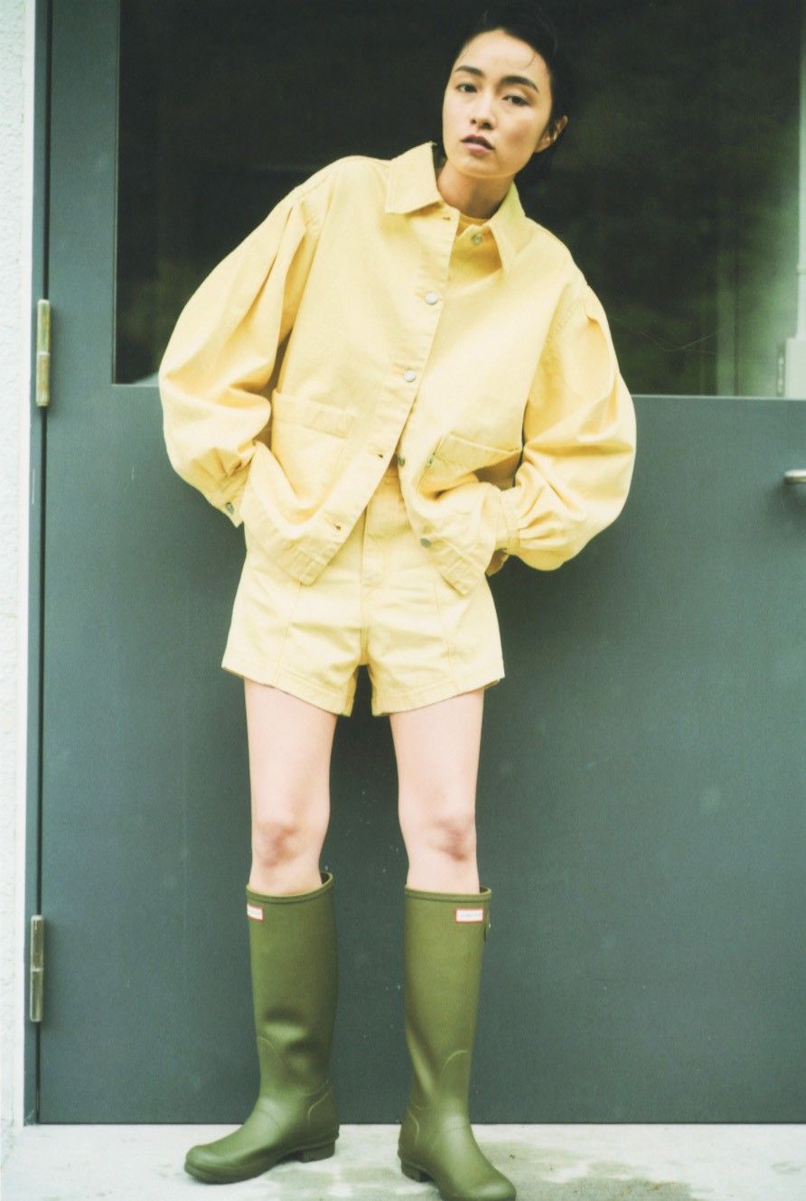 リーバイスフレッシュのイエローのジャケット、ショートパンツにハンターのブーツを合わせたモデル