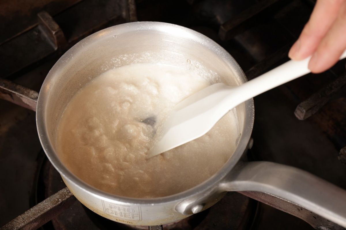 酒粕を鍋に入れて火にかけ、溶かしている様子
