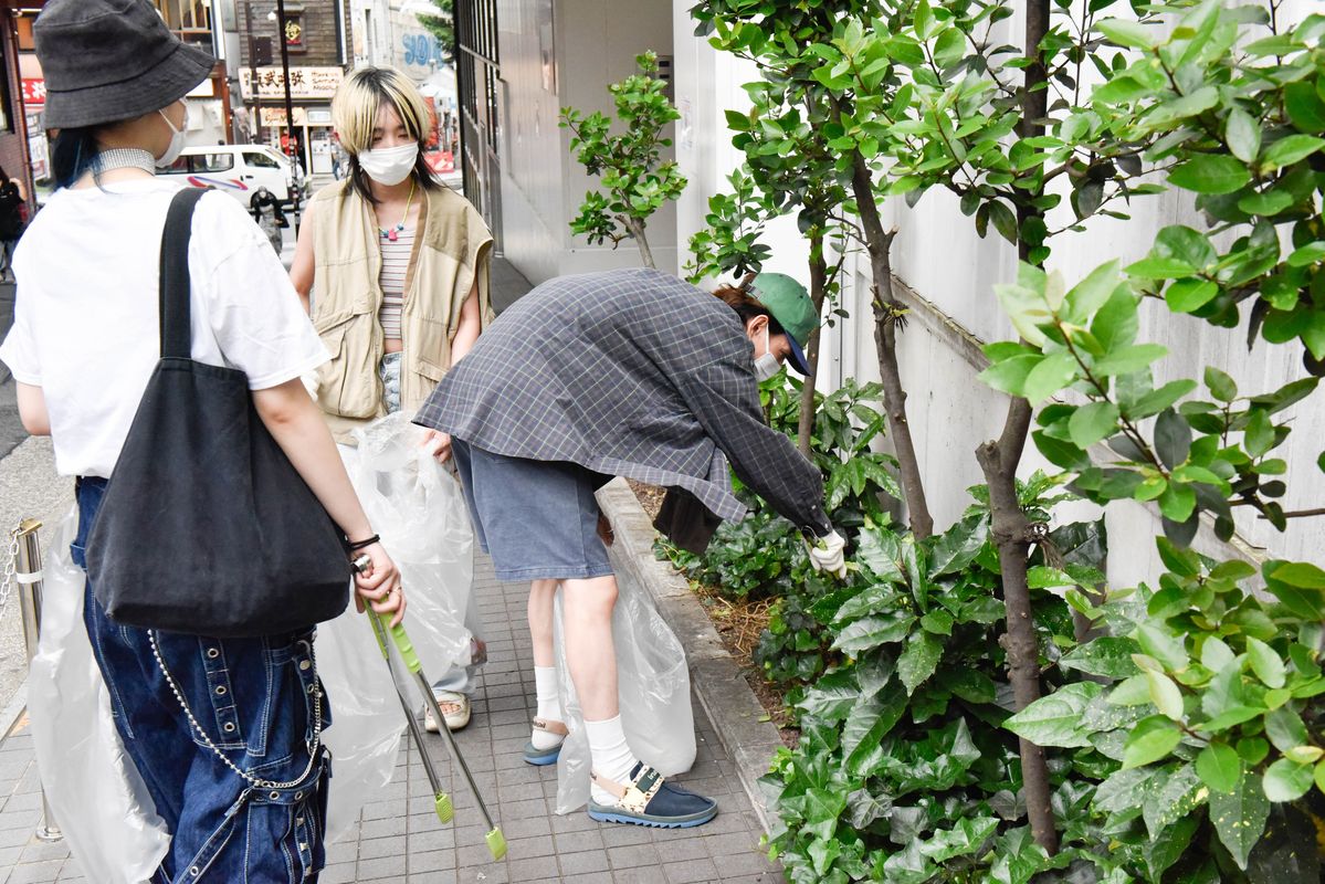 花壇のごみ拾いをする参加者たち