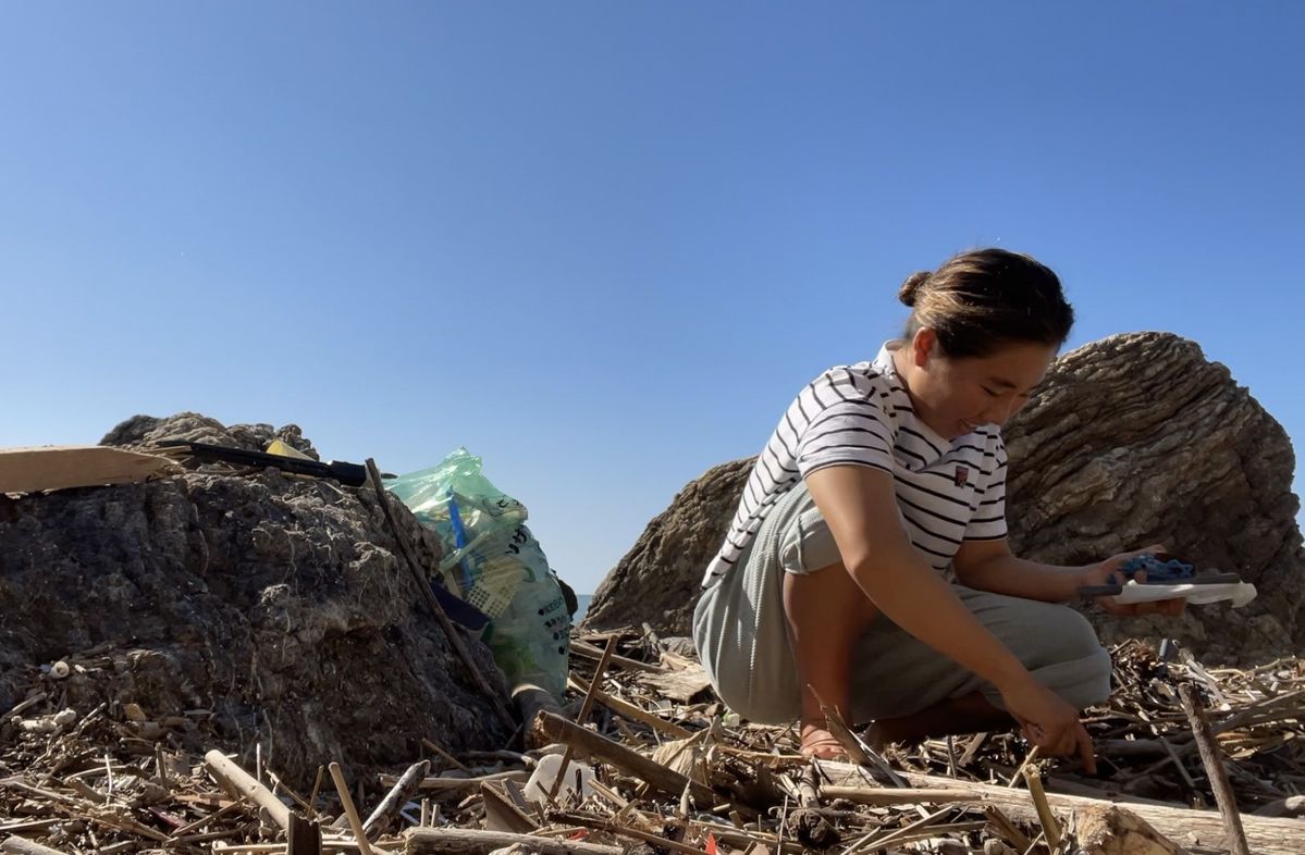 ビーチクリーンをするプロサーファー都築 虹帆選手