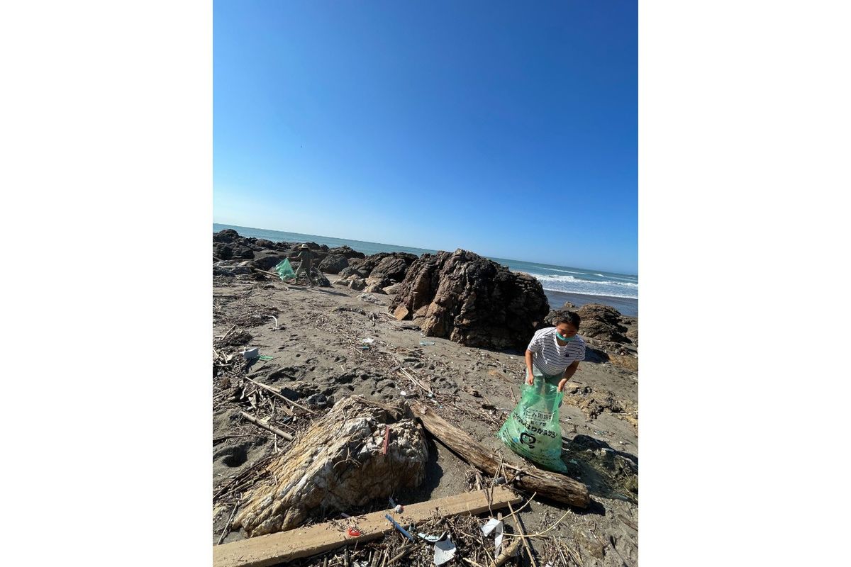 あかばね塾の活動としてビーチクリーン中の都築選手