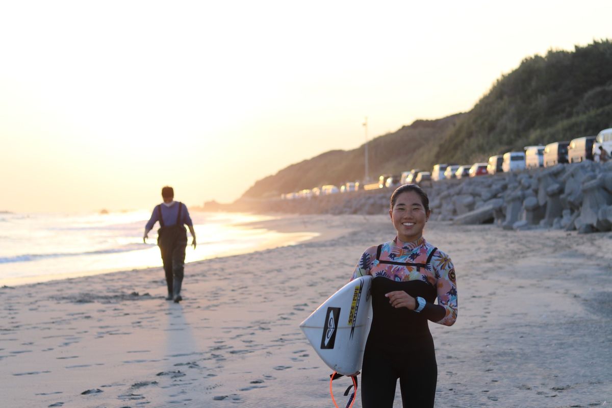 サーフボードを手に持つ都築選手