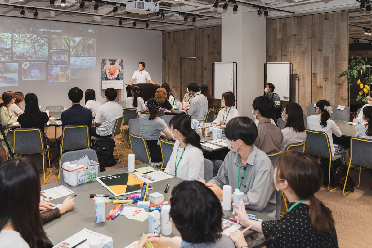 登壇する明治社員の方の説明を聞く参加者たち