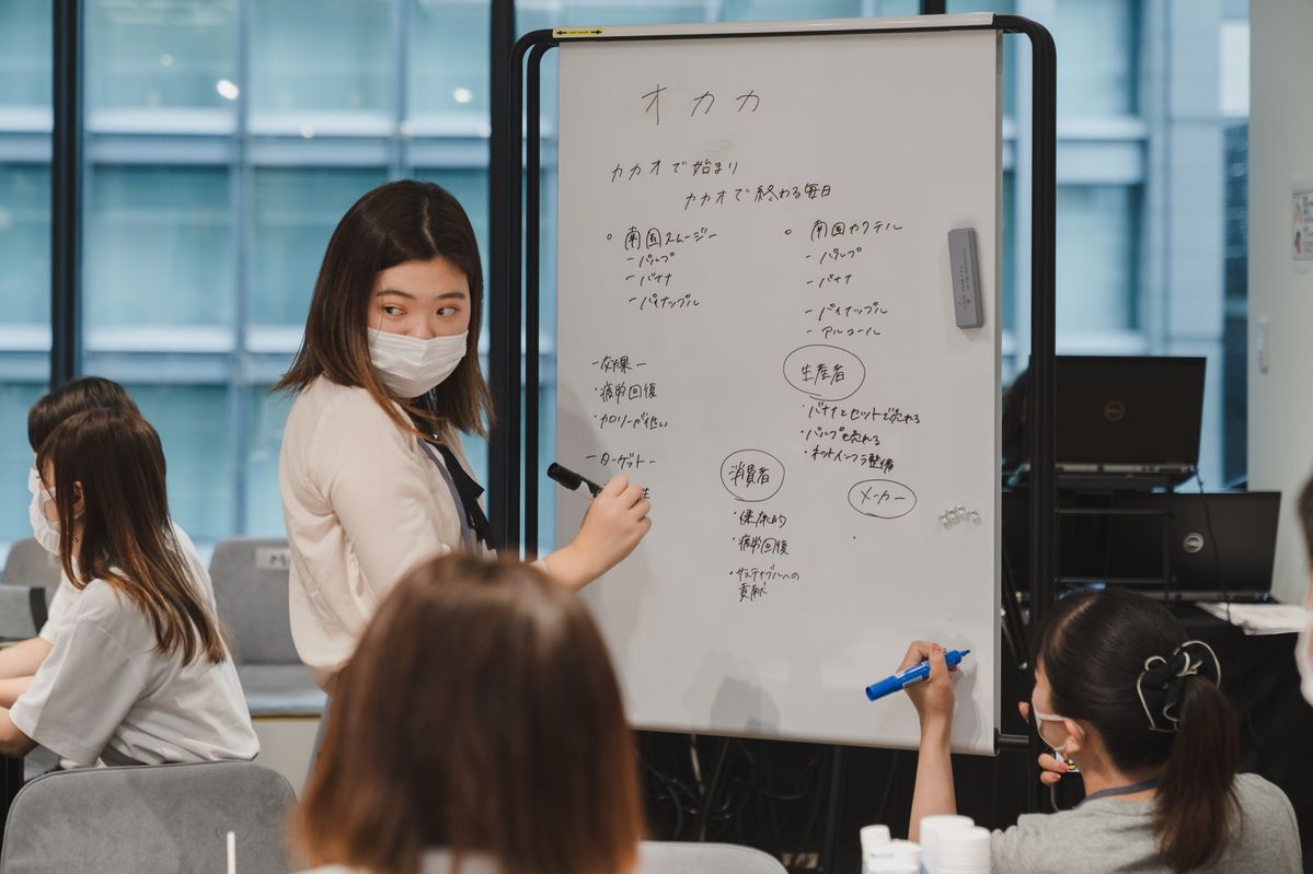 ホワイトボードにアイデアを書いている参加者