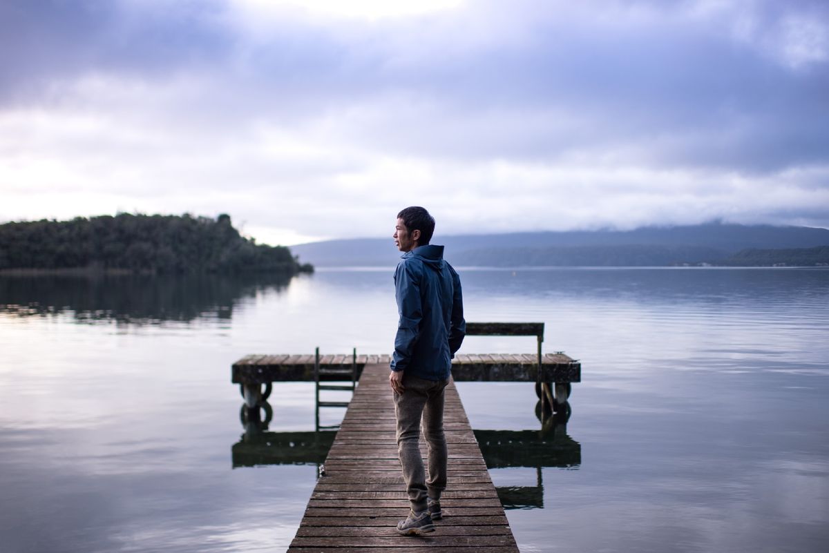 ニュージーランドの湖の桟橋に立つ四角さん