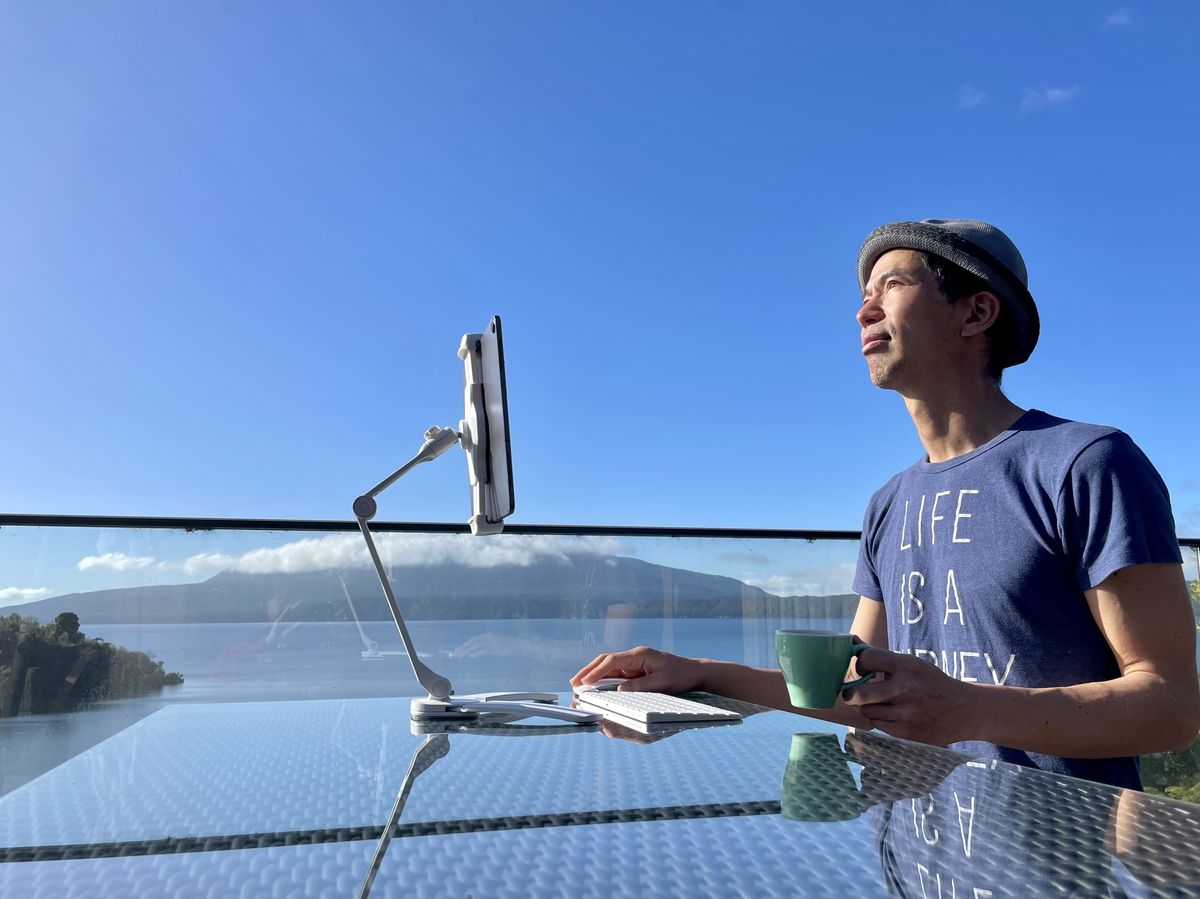 ニュージーランドの湖畔のテラスでiPadを見ている四角さん