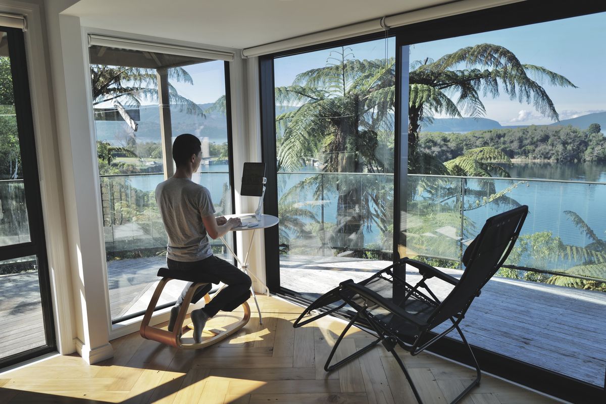 湖を眺めながら自宅でデスクワークをする四角さん