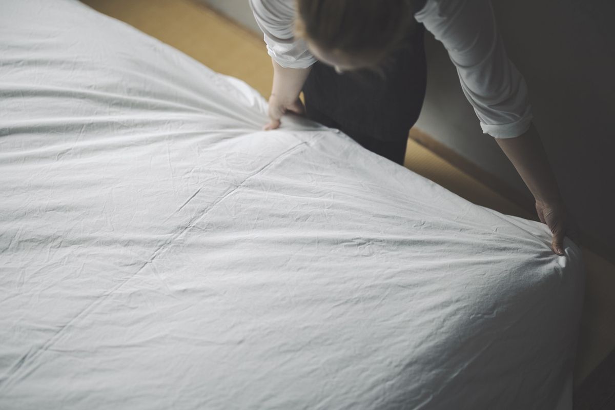 シーツを敷く女性