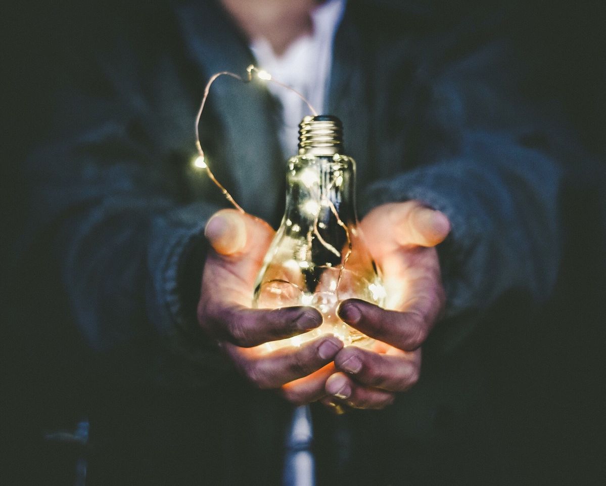 白熱電球を持っている人の手