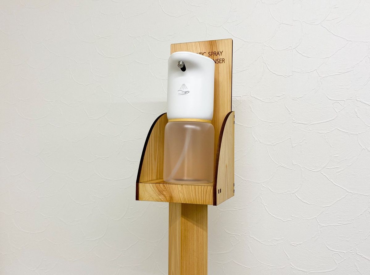 木製スタンドにアルコールディスペンサーを置いた風景