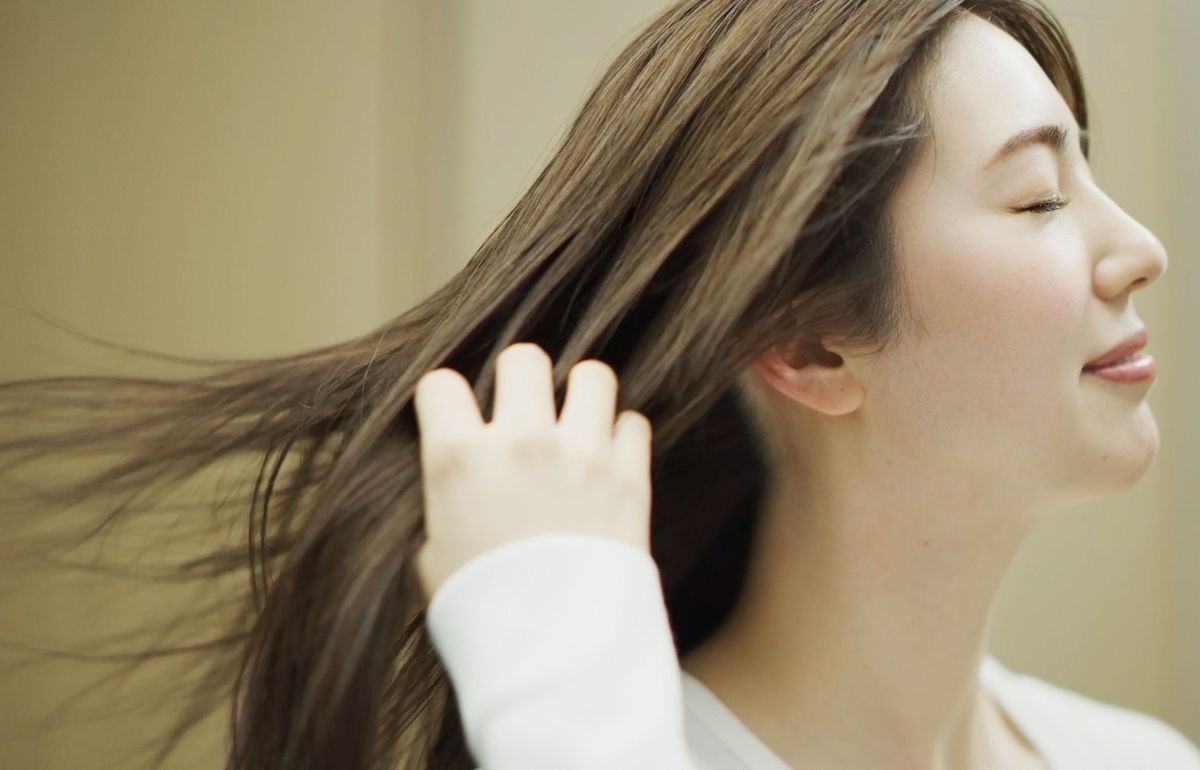 さらさらの髪をなでる女性