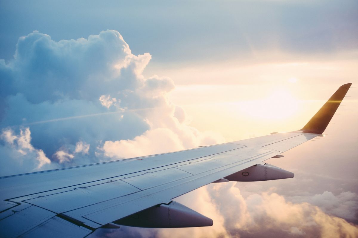 飛行中の飛行機の窓から見える飛行機の翼と空