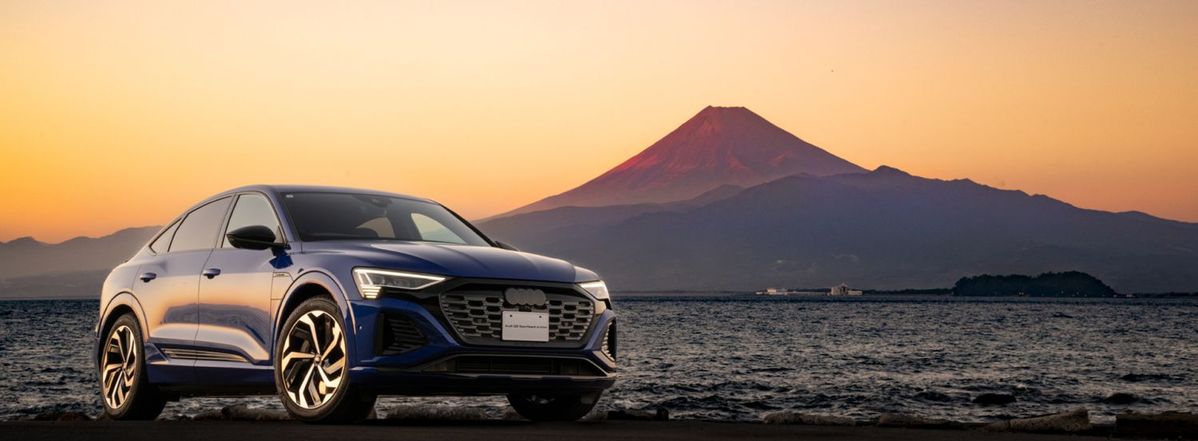 夕暮れの富士山を背景にしたAudiの車
