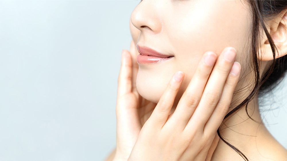 自分の肌をさわる女性