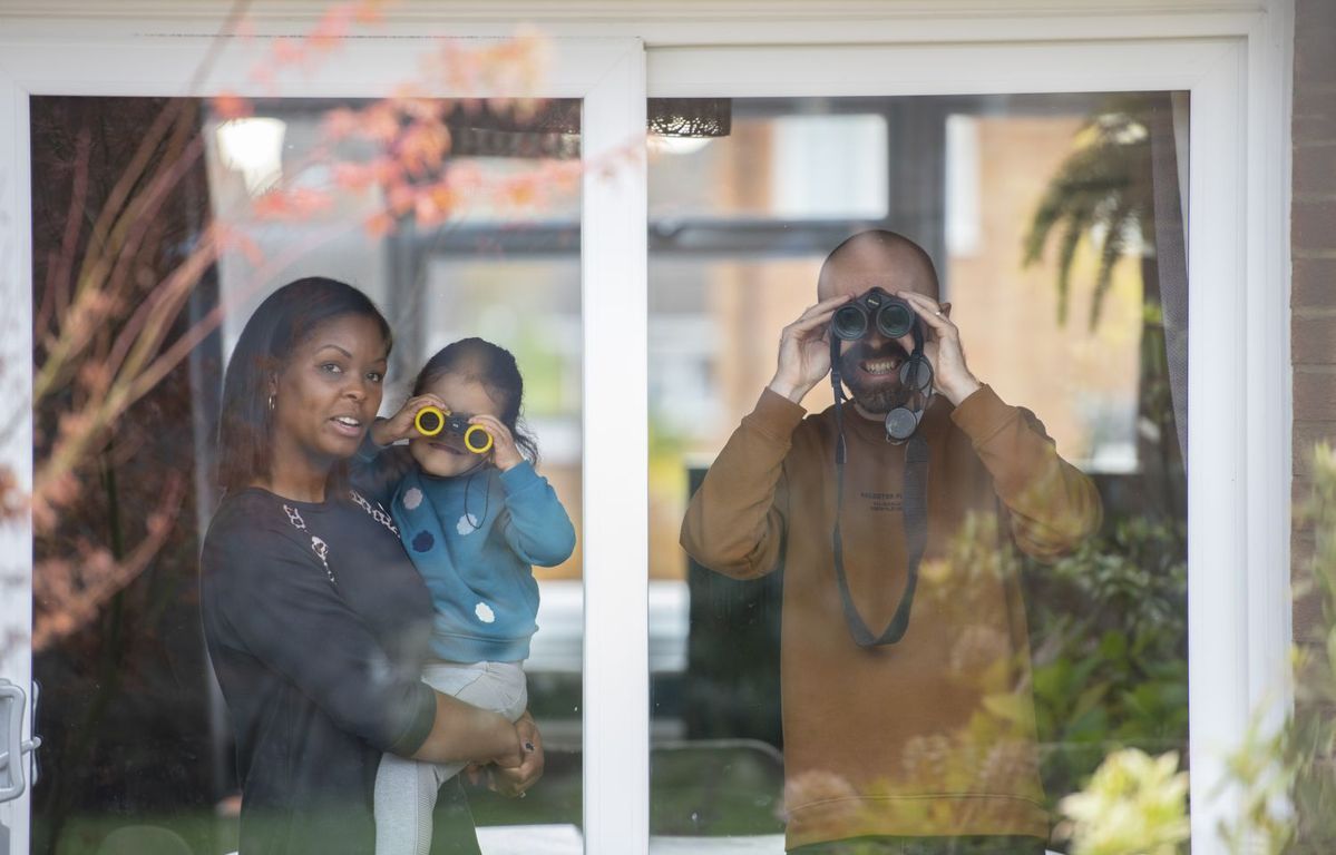 家の中から庭の野鳥を観察する家族