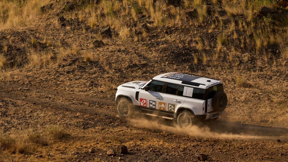 オフロード性能を発揮して草原を走行するディフェンダー（DEFENDER）