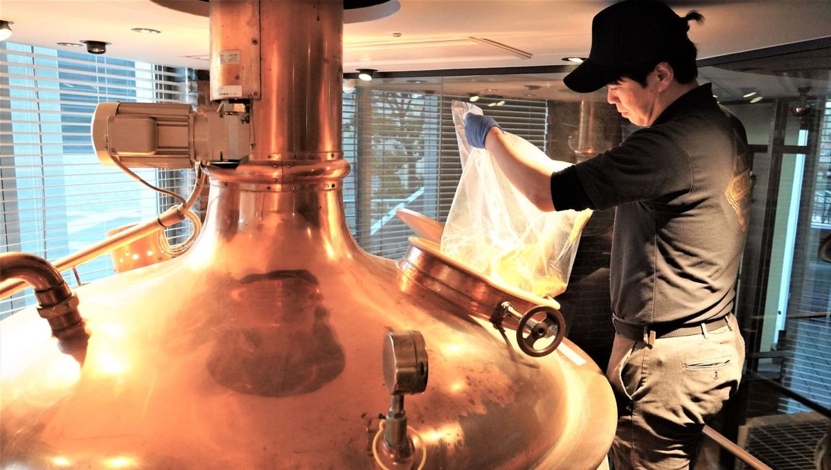 仕込槽にバウムクーヘンを投入する様子の写真