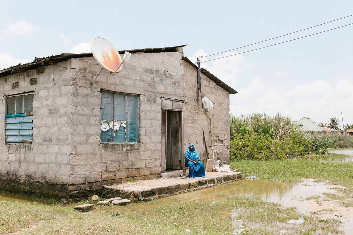 古い家の前に佇む中東の女性の写真