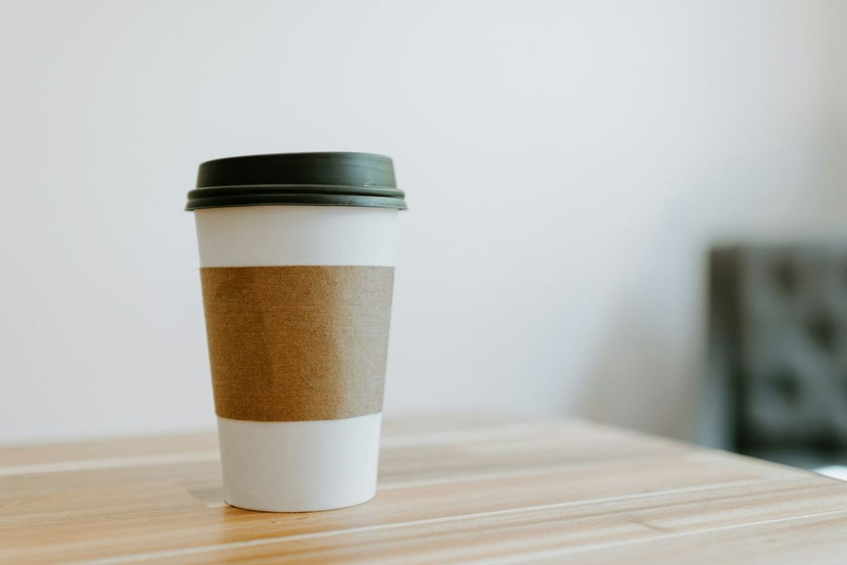机に置かれた紙のコーヒーカップ