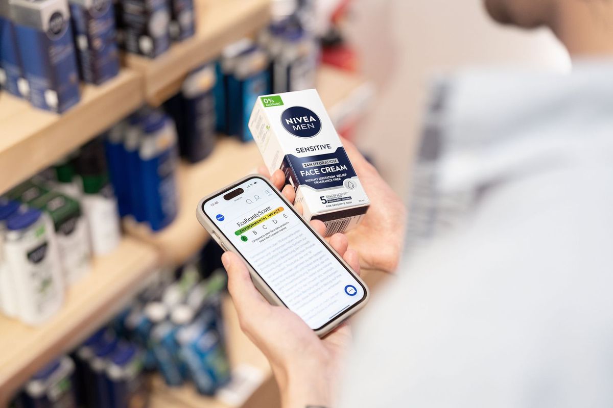 NIVEA MENのアイテムで「エコビューティースコア」の画面を確認する男性