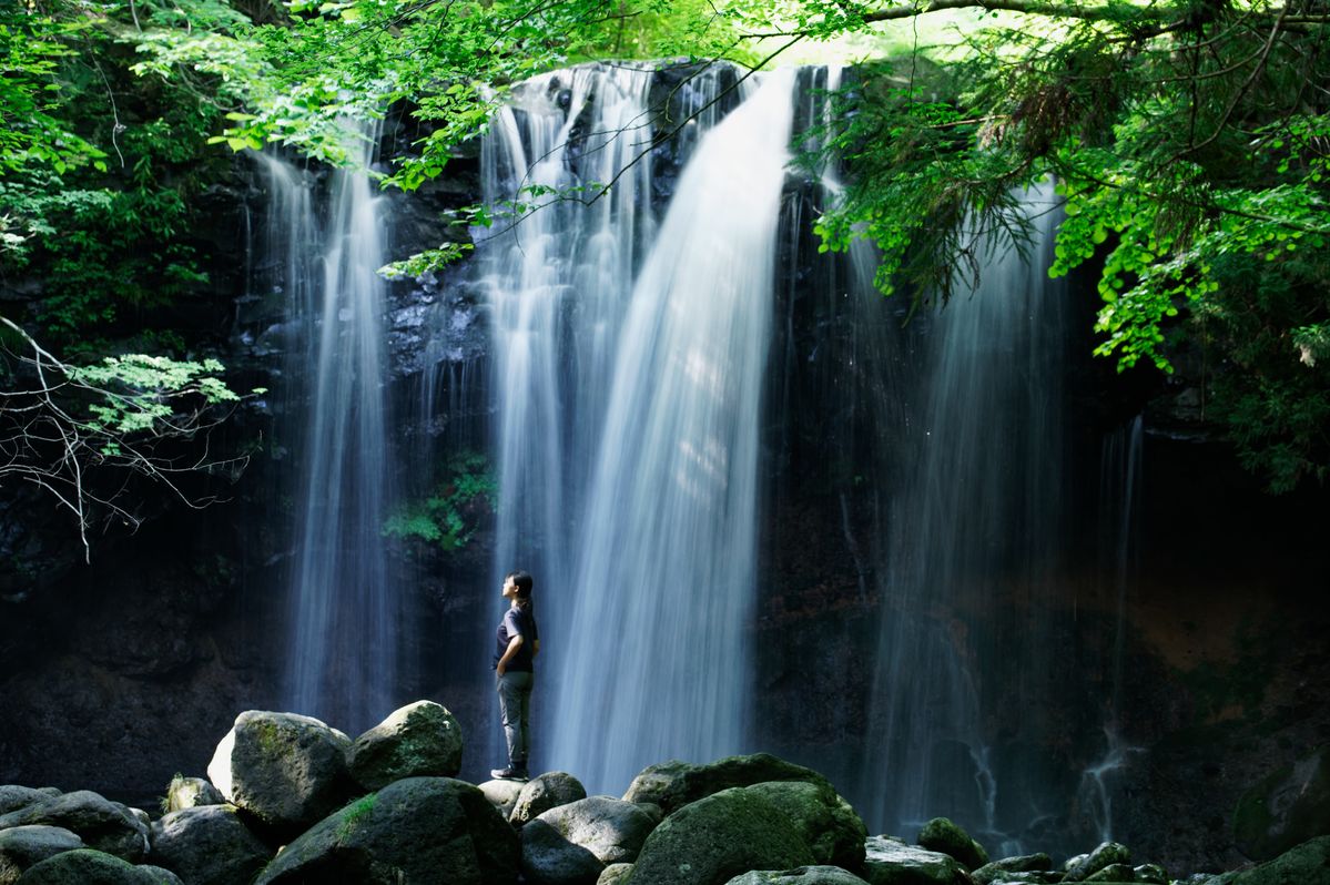 滝壺にたたずむ女性