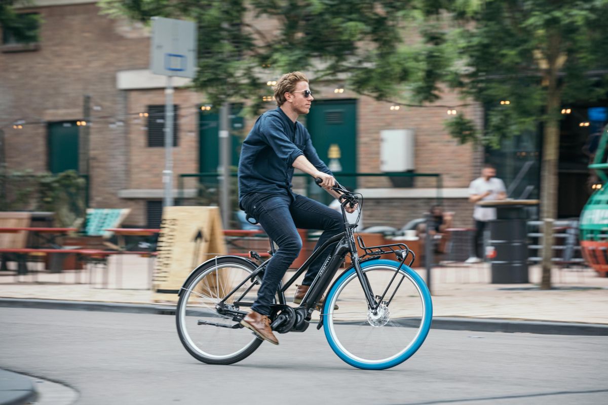 「Swapfiets」の自転車に乗る男性