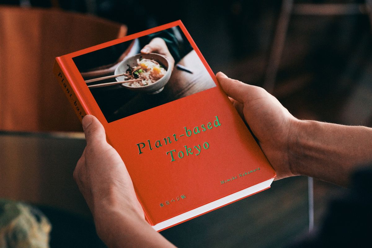 『Plant-based Tokyo 東京ベジ帖』の本を持っている様子