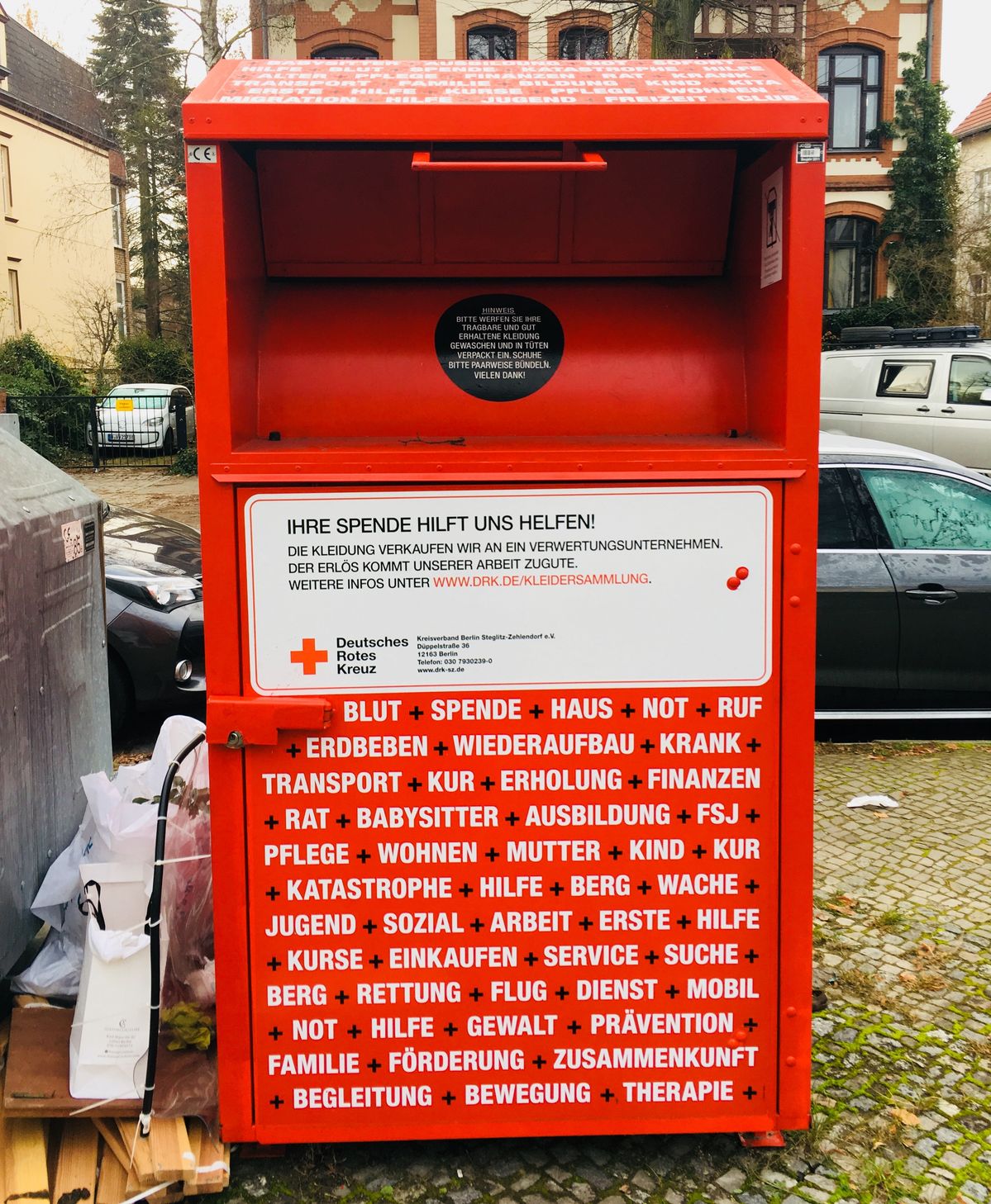 赤い、赤十字の文字が沢山書いてある古着回収ボックス