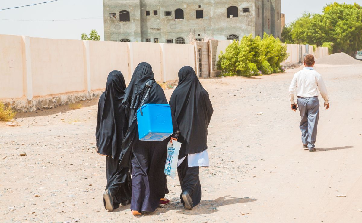 ヒジャブを着た人物が道を歩く様子