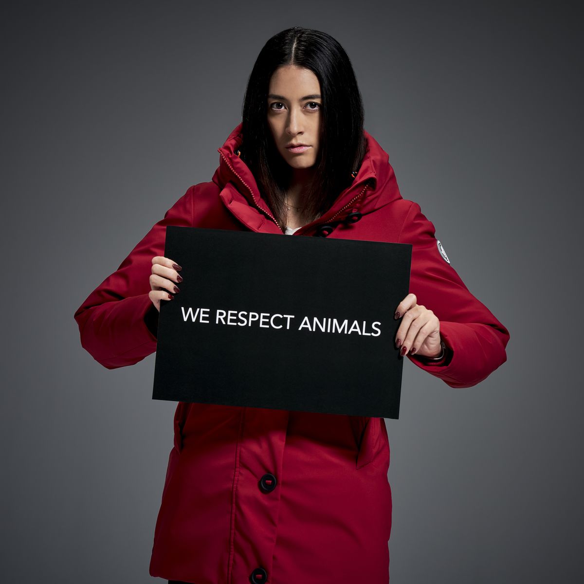 赤色のアウターを着てメッセージカードを持つ森泉氏