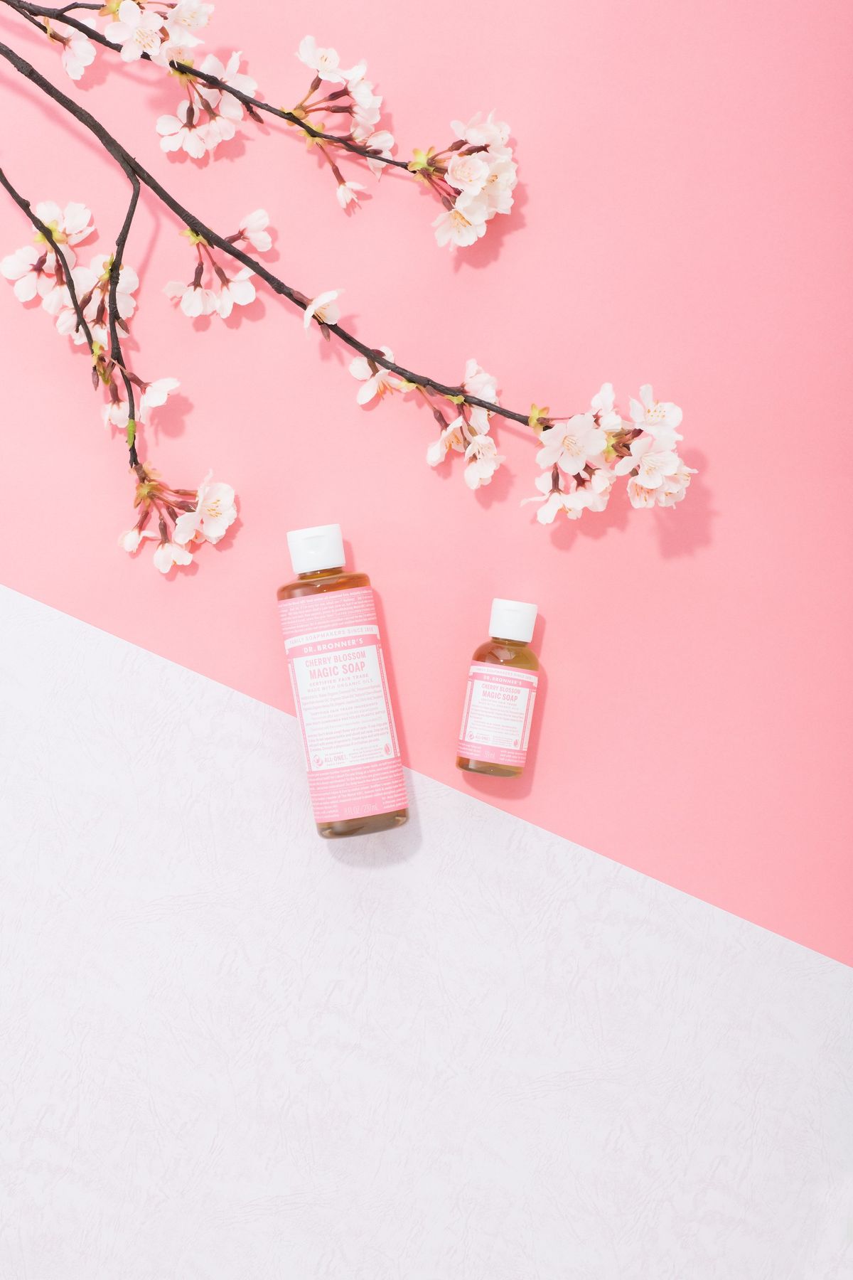 ピンクと白の背景に置かれた「ドクターブロナー チェリーブロッサムセット」