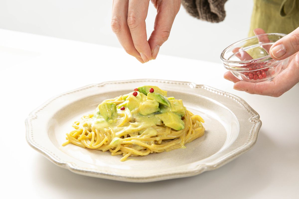 ZENB NOODLEでつくったアボカドのパスタにレッドペッパーをかけているところ