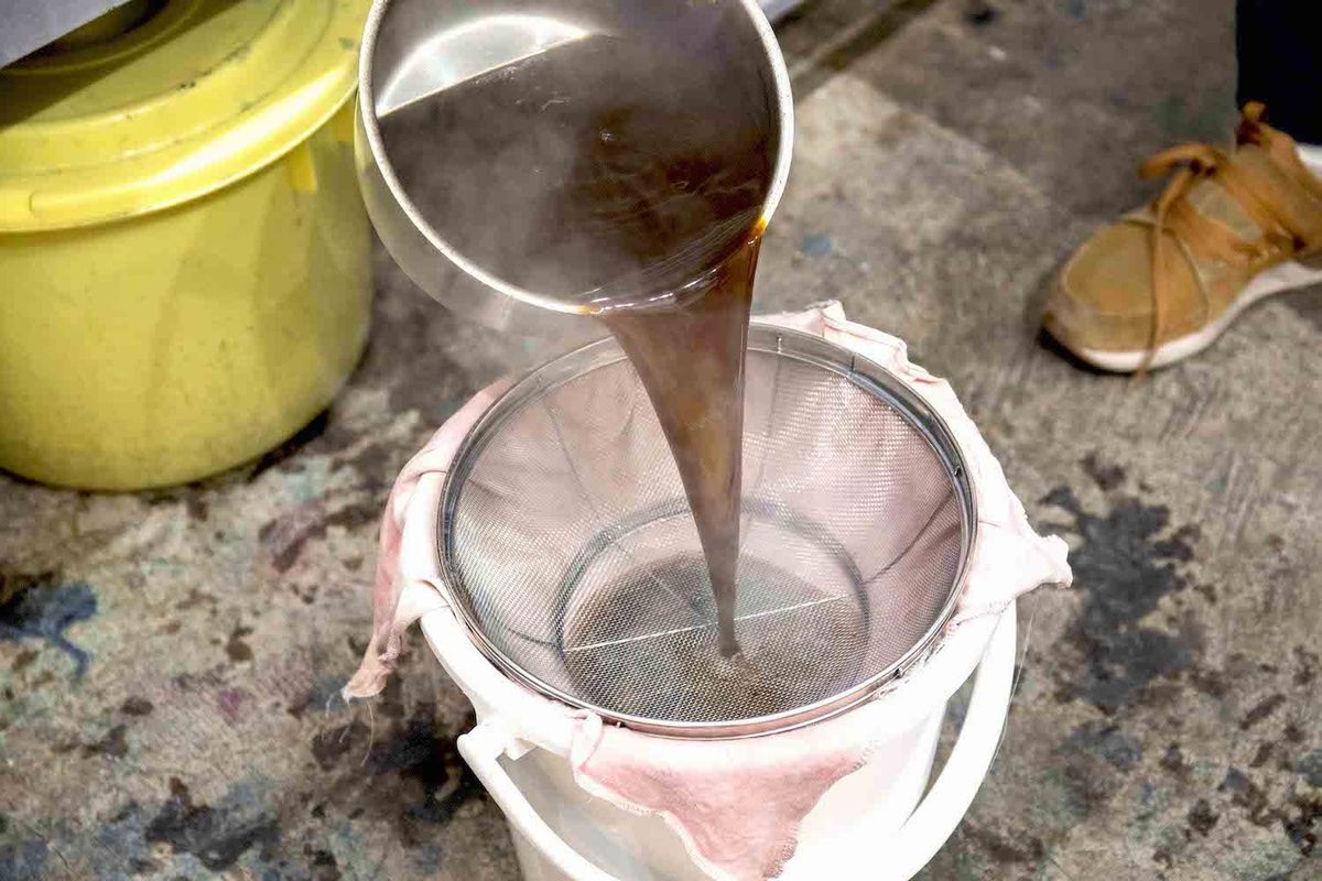 コーヒー染めの染液を濾している様子