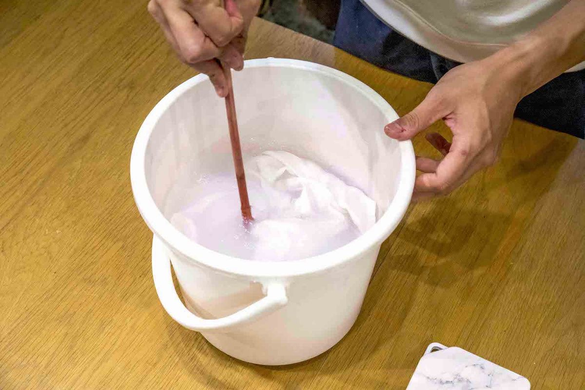 コーヒー染めでシャツをかき混ぜている様子