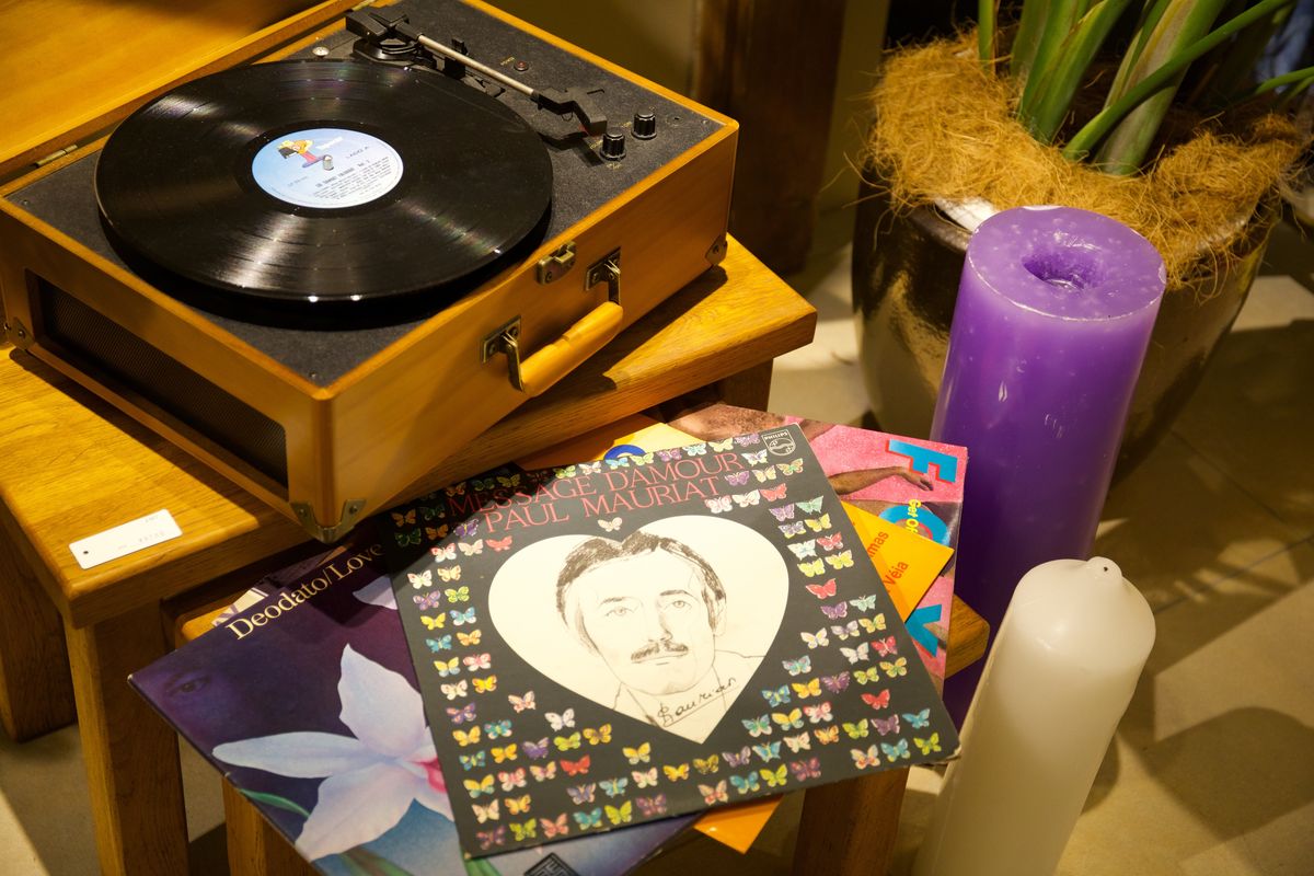 レコードプレーヤーとレコード、キャンドルが置かれたチェア